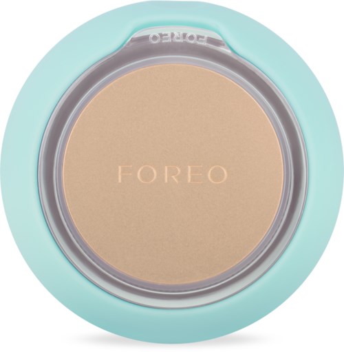En turkos rund enhet med en beige mittdel som visar ordet "FOREO". Det verkar vara en hudvårds- eller skönhetsapparat.
