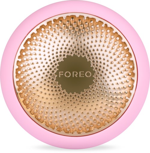 En rund rosa enhet med gullfargede ansiktet, merket 'FOREO,' med mange små prikkete bumpere for hudpleie.