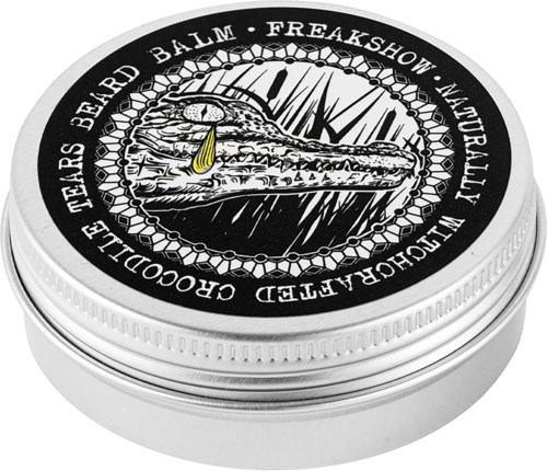 En rund burk med krokodilets illustration, ett gult dropp och svartvitt text runt locket.