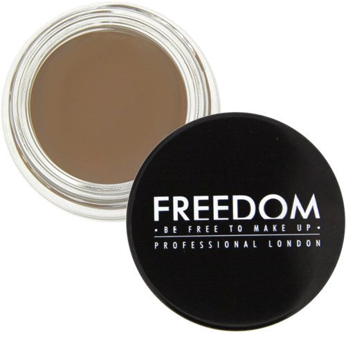 En liten rund beholder med svart lokk som sier 'FREEDOM' og 'BE FREE TO MAKE UP'. Lokket sier også 'PROFESSIONAL LONDON'.