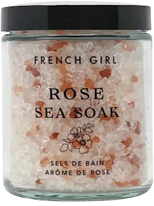 A jar of pink and white bath salts labeled 'French Girl Rose Sea Soak' with a simple flower drawing.