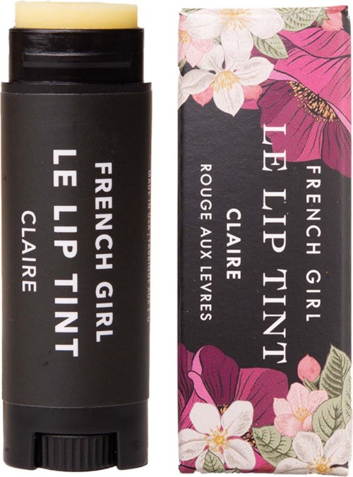 A black lip balm stick next to a floral packaging box with pink and white flowers on a dark background.