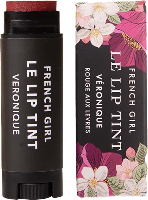 A black lip balm container beside a floral box with pink, white, and green flowers. Label says 'French Girl Le Lip Tint.'