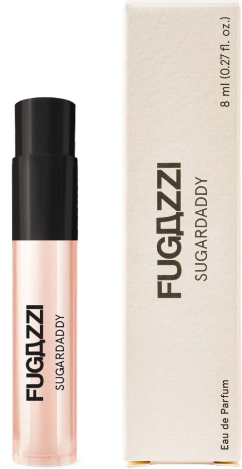 A small perfume bottle with pink liquid next to a white box labeled 'FUGAZZI SUGAR DADDY' and 'Eau de Parfum.'