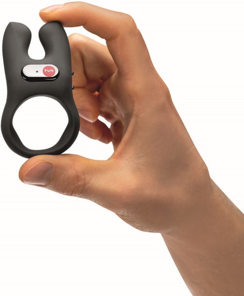 A hand holds a small black device with a loop, a silver button labeled "FUN," and a red oval.