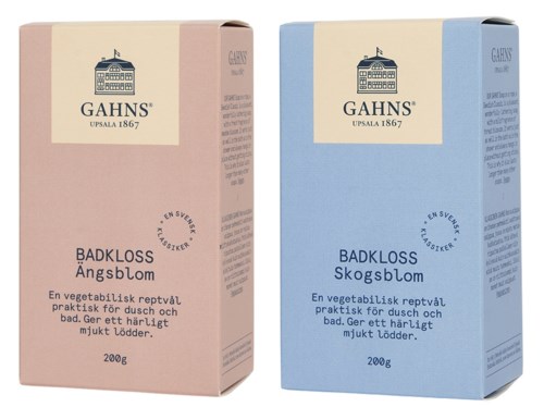 Två boxar med växtbaserat badsalt, en rosa och en blå, med svensk text som beskriver deras lugnande egenskaper.