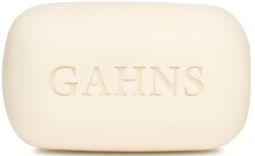 Ein weißer Seifenblock mit dem Wort "GAHNS" eingestanzt, rund und glatt.