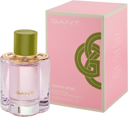 A perfume bottle with pink liquid and a green cap next to a pink box with a gold and green logo and text.