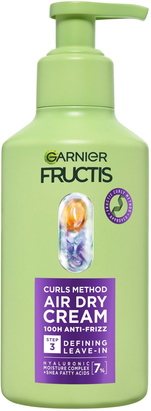 En ljusgrön flaska med pump, märkt Garnier Fructis lufttorkande kräm för lockigt hår med anti-frizz-teknik.