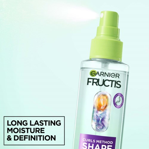 A clear spray bottle with green nozzle, labeled Garnier Fructis Curls Method, promotes long-lasting moisture and curl definition.