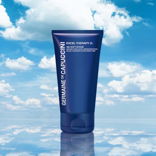 A blue tube of facial scrub against a sky with clouds and a reflective water surface.