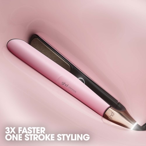 En rosa plattång märkt 'ghd platinum+'. Den är placerad på en rosa yta och visar sin slanka design.