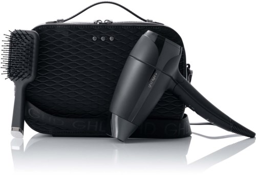 A black travel case with a hairdryer, a brush, and a small comb inside. All are placed in front of the case.