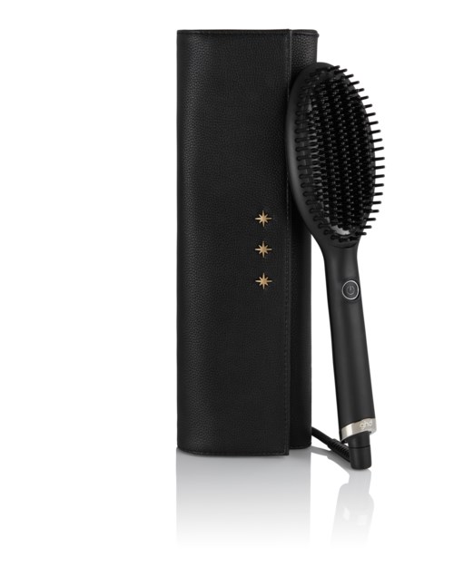 A black hairbrush with a handle, placed upright next to a black case, featuring three gold stars on it.