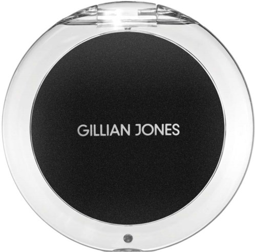 En kompakt, rund sminkspegel med svart bakgrund och vitt text som säger "GILLIAN JONES."