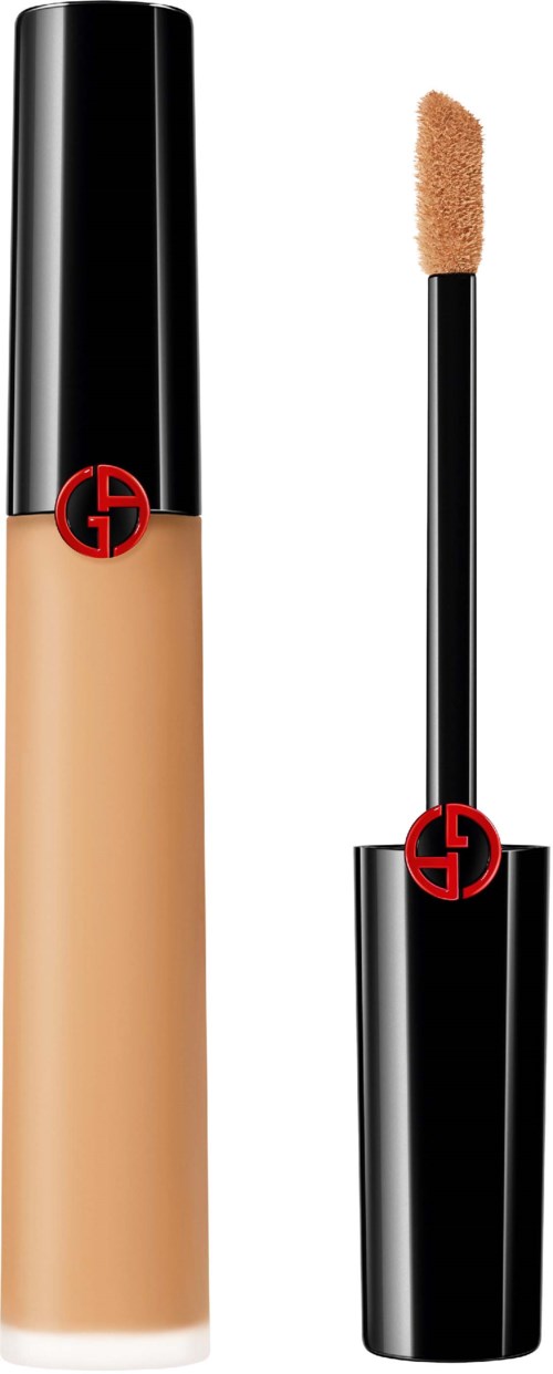 En concealer-emballasje med beige væske og en påføringspensel med svamp. Begge har en svart og rød logo.