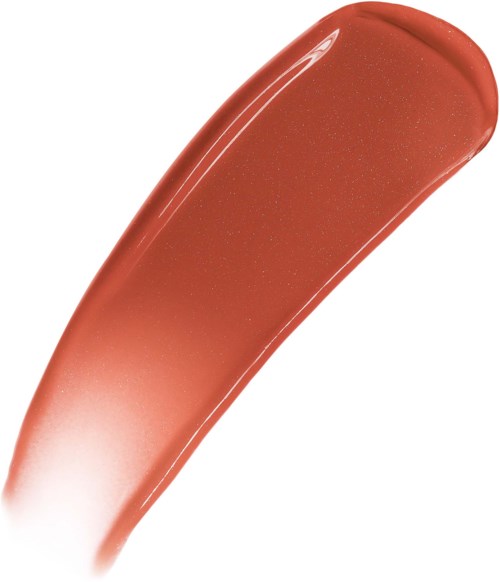 En smula av persikofärgad läppstift med glittrande gnistor på en vit bakgrund.