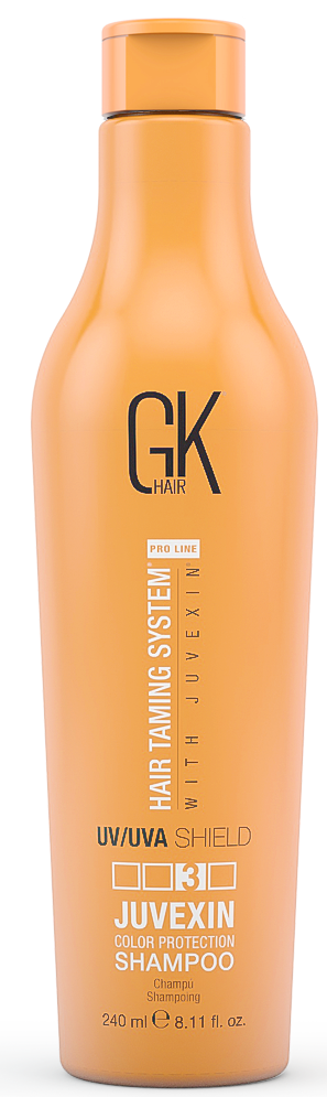 En lang, oransje flaske med GK hårsjampo med pumpe, merket for fargebeskyttelse og UV/UVA-skjold.