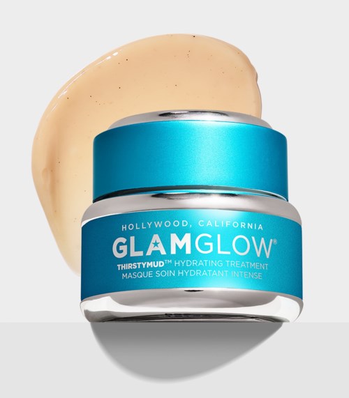 En lille blå glas med Glamglow hudplejecreme og beige creme spredt ved siden af.