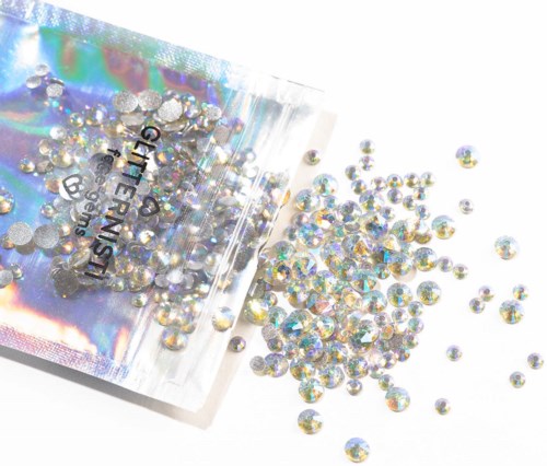 Small shiny rhinestones spill out of a clear plastic bag labeled "GIRLFRIEND".