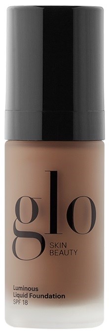 En flaske med flytende foundation med svart lokk, merket 'glo SKIN BEAUTY' og 'Luminous Liquid Foundation SPF 18'.