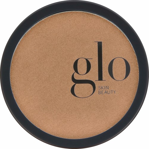 En kompaktpuderbehållare med beige pulver inuti, svart kant och orden "glo SKIN BEAUTY" på texten.