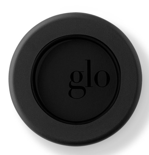 Ett svart runt föremål med ordet "glo" framme i mitten. Det ser ut som ett lock eller en liten skål.
