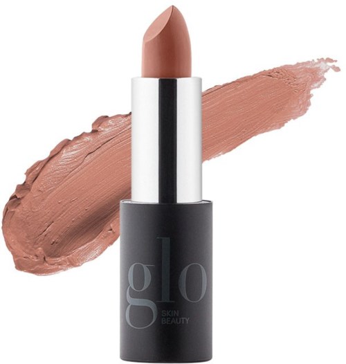 A lipstick in a silver tube with a brown shade, with a swatch of the lipstick spread behind it.