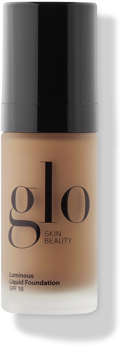En flaske flytende foundation merket 'glo Skin Beauty Luminous Liquid Foundation SPF 18' med svart hette og beige væske.