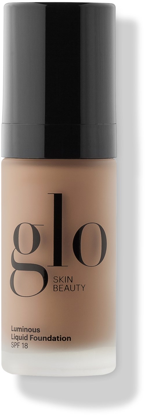 Glo Skin Beauty nestemäinen meikkivoide pullo, SPF 18. Se on beigen värinen ja sillä on musta korkki.