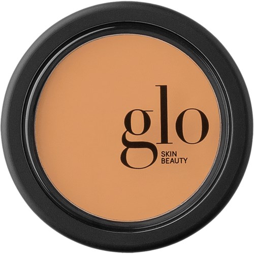 Een compacte ronde container met perzikhuidige bovenkant, zwarte rand en de naam 'glo Skin Beauty' binnenin.