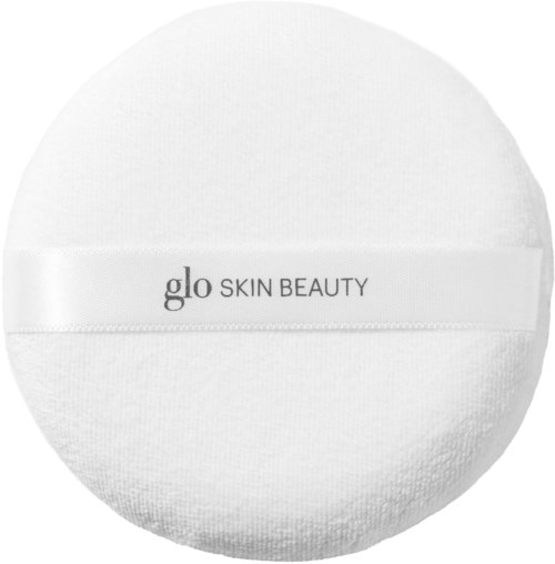 A round, white cosmetic puff with a label that says "glo SKIN BEAUTY."