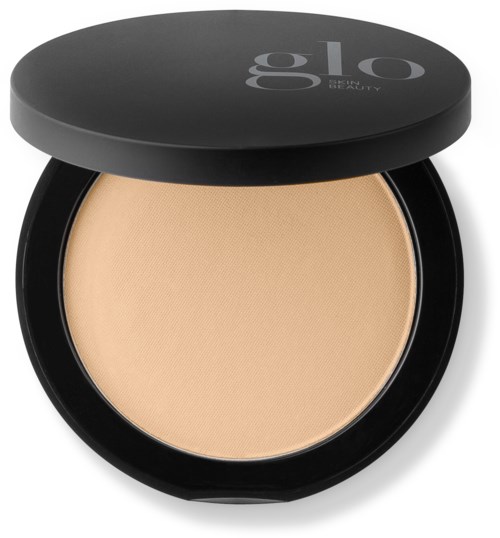 En rund svart kompakt med beige ansiktspudder og lokk med merket 'glo'.