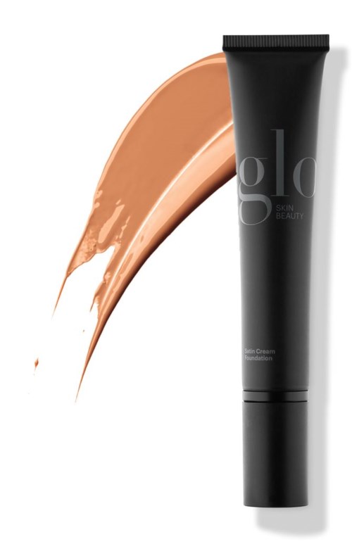 En svart tube med foundation og en beige sminkeprøve ved siden av.