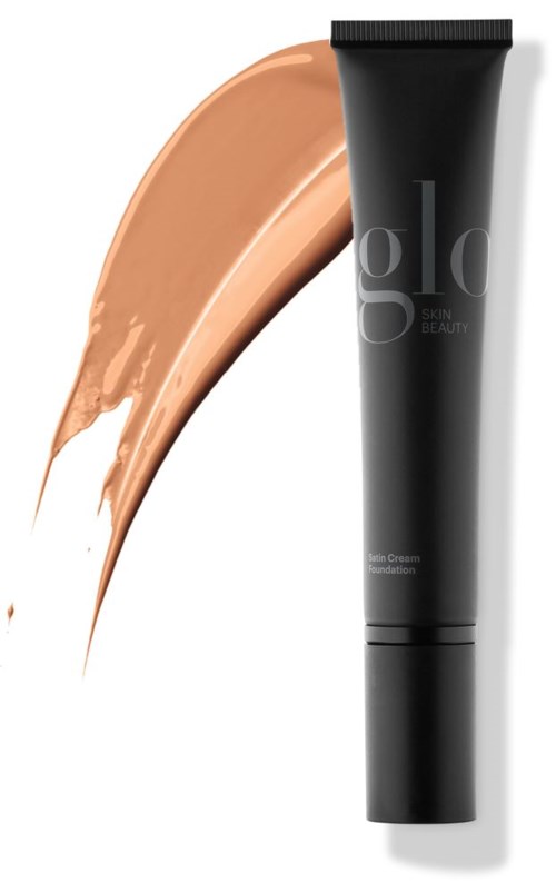En svart tube med foundation for huden med beige foundation ved siden av.
