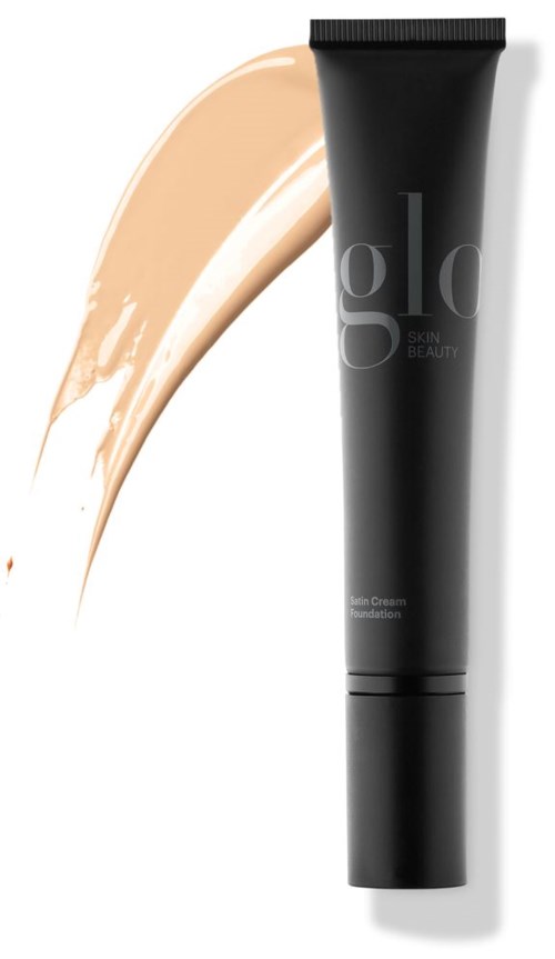 En svart tube med 'glo' skrevet på, ved siden av en beige ansiktskrem.