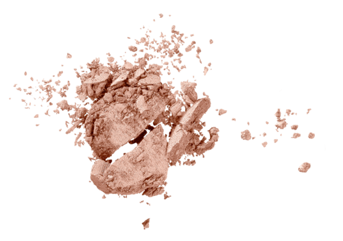 Et knust makeuppulver med spredte biter mot en svart bakgrunn.