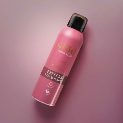 En rosa flaske av Glöd Sophie Elise foam dark spray på rosa bakgrunn.