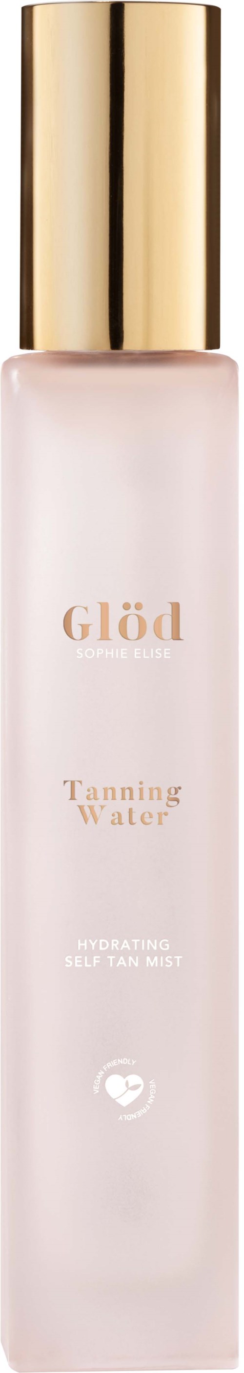 En lång, smal vit flaska med guldlock, märkt Glöd Tanning Water, används för förberedelse av solbränna.
