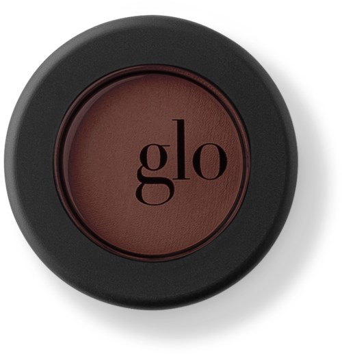 En rund makeup-rouge-kompakt i svart med brunt till rött rouge, märkt med "glo" i svarta bokstäver.