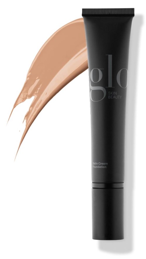 En svart tube med ansiktskrem med beige foundation ved siden av.