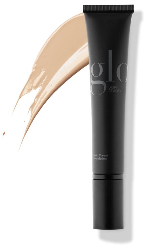 En svart tube med hudgrunn og teksten 'skin care' på, med en beige foundation ved siden av.
