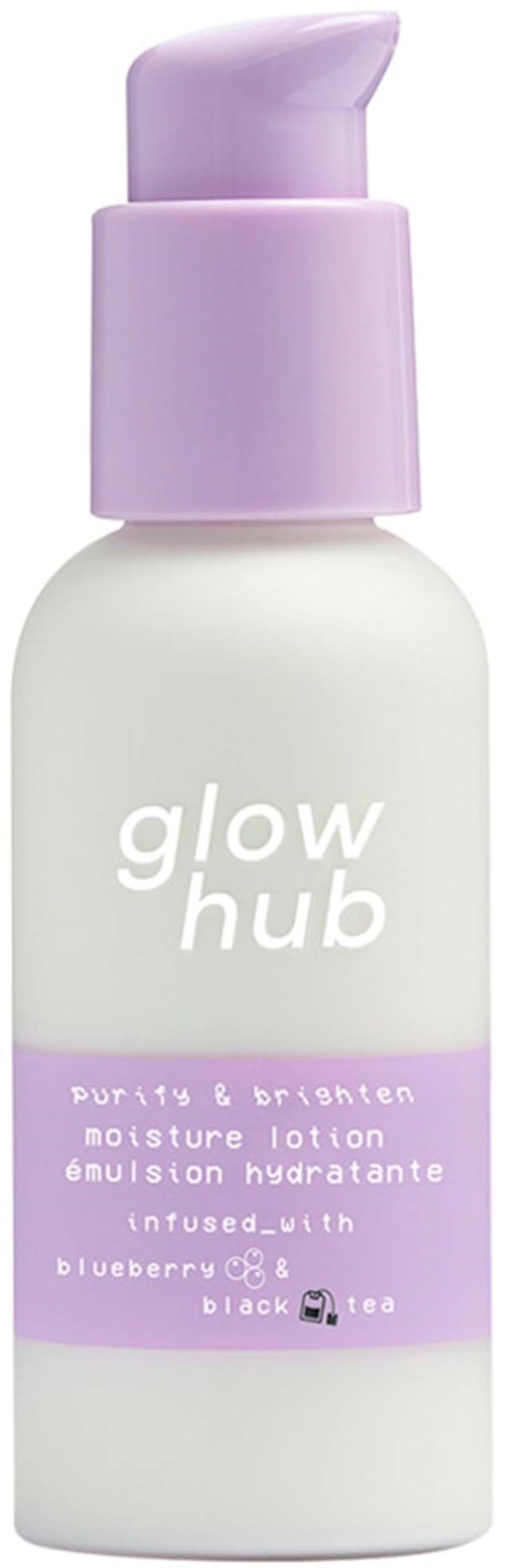 En hvit flaske med lilla pump merket "glow hub." Den inneholder fuktighetslotion med blåbær og svart te duft.