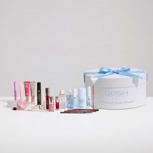 Eine Sammlung von Hautpflege- und Makeup-Produkten neben einer weißen Geschenkbox mit blauem Band.
