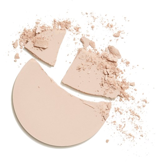 En rund beige makeup-kompakt er knust i bidder med pulver spredt omkring.