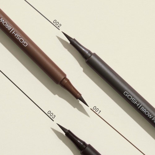 Zwei braune und schwarze Marker liegen auf einem Papier mit Linien und Zahlen, zum Zeichnen oder Schreiben verwendet.