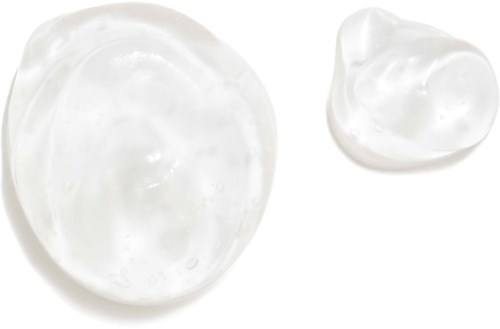 Två klickar av vitt kräm eller lotion på en vit bakgrund, en större och en mindre.
