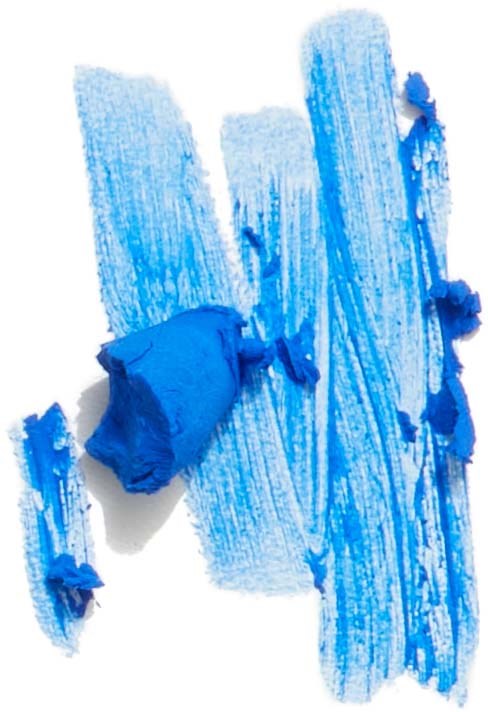 Blue chalk smudged on a white surface with some broken pieces nearby.