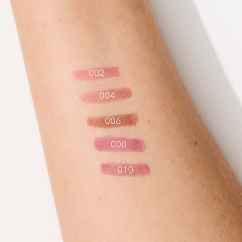 Swatches of five different lipstick shades numbered from 002 to 010 on a person's arm.
