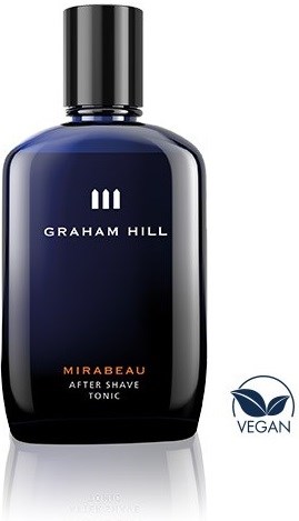 En blå flaska med svart lock. Den är märkt Graham Hill Mirabeau after shave tonic. Vegansymbol finns.